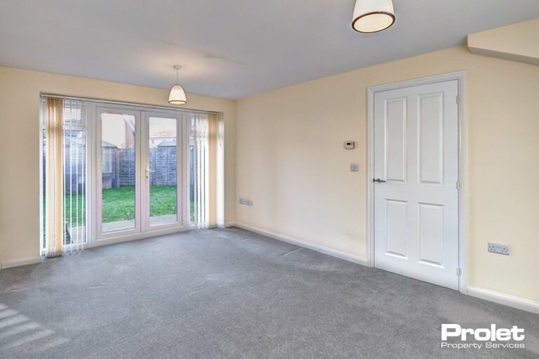 Magnolia walls and grey carpet with French doors to garden