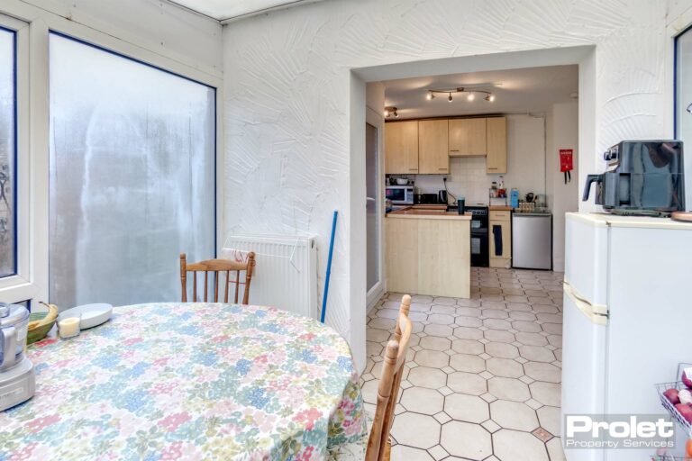 Kitchen diner with dining table and chairs, skylight and kitchen in background